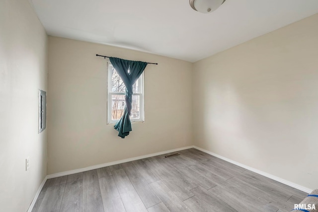 spare room with visible vents, baseboards, and wood finished floors