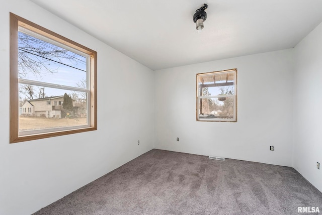 unfurnished room featuring visible vents and carpet flooring