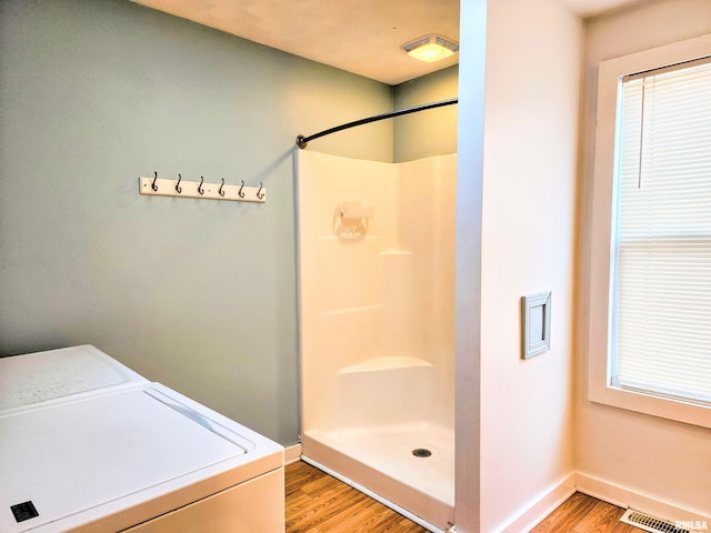 bathroom with walk in shower, wood-type flooring, and washer and dryer