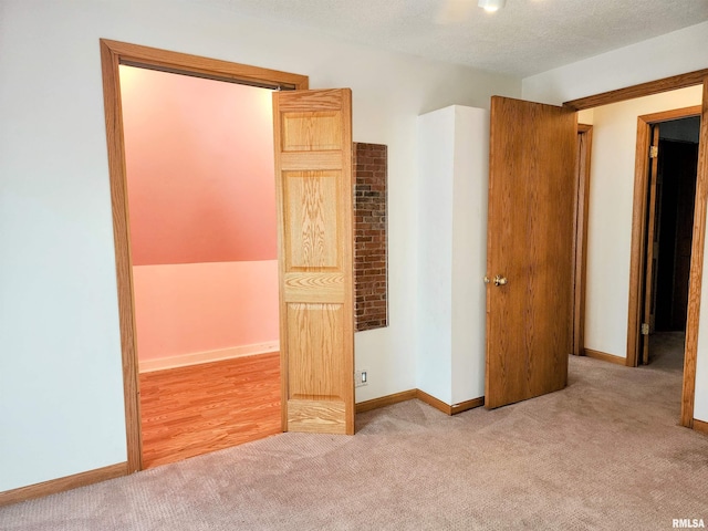 unfurnished bedroom featuring light colored carpet and a textured ceiling