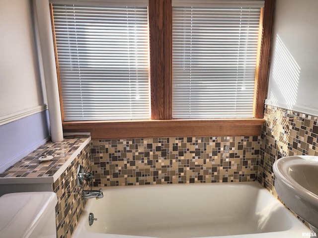 bathroom with a washtub and toilet