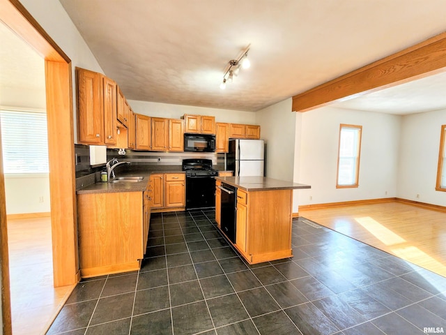 kitchen with sink, track lighting, a kitchen island, dark tile patterned floors, and black appliances