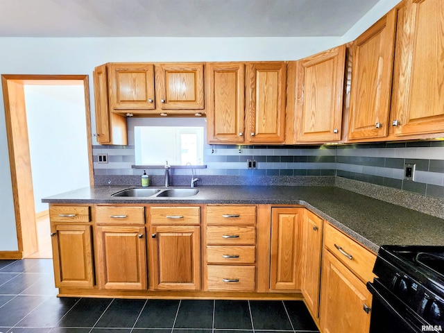 kitchen with sink, backsplash, black stove, and dark tile patterned flooring