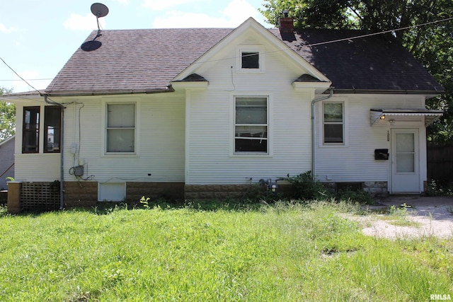 rear view of property featuring a lawn