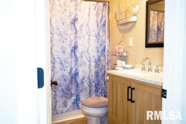 bathroom featuring walk in shower, vanity, and toilet