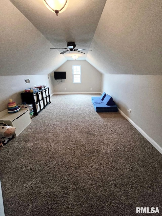 additional living space with ceiling fan, vaulted ceiling, a textured ceiling, and carpet