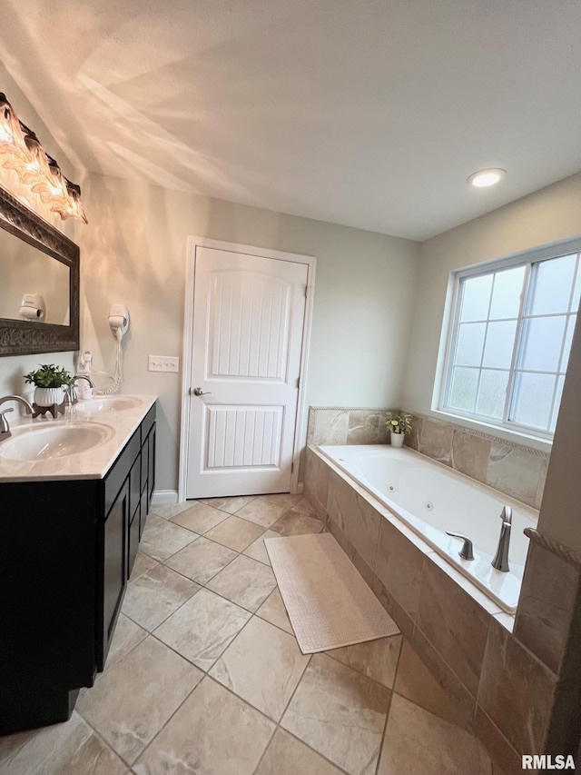 bathroom featuring vanity, tile patterned flooring, and tiled tub