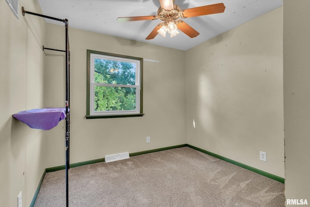 empty room featuring carpet flooring and ceiling fan