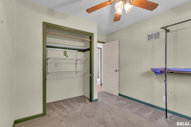 unfurnished bedroom featuring light carpet, ceiling fan, and a closet