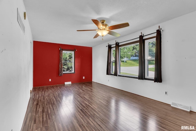 spare room with a textured ceiling, dark hardwood / wood-style floors, and ceiling fan