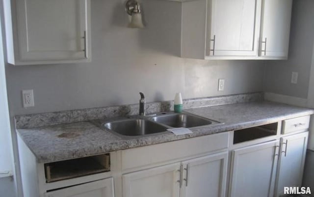 kitchen featuring white cabinetry and sink