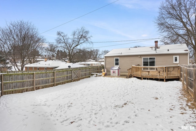 snow covered back of property featuring a wooden deck