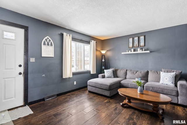 living room with dark hardwood / wood-style floors and a textured ceiling