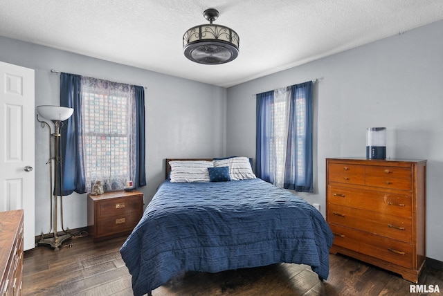 bedroom with dark hardwood / wood-style flooring and a textured ceiling