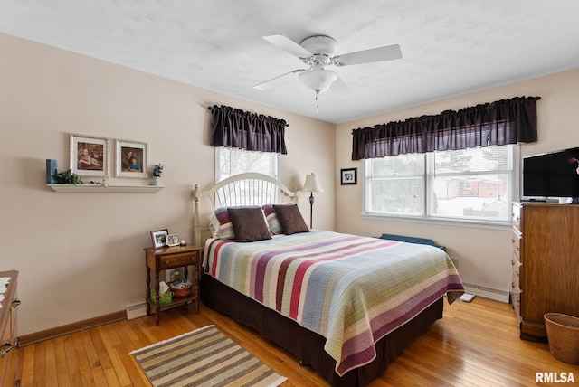 bedroom featuring ceiling fan, light hardwood / wood-style floors, and baseboard heating