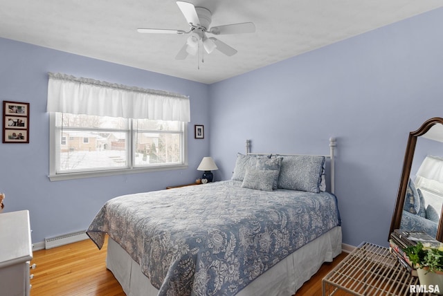 bedroom featuring hardwood / wood-style flooring, a baseboard radiator, and ceiling fan