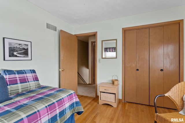 bedroom with light hardwood / wood-style flooring and a closet