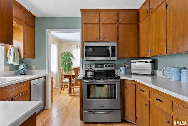 kitchen with stainless steel appliances and light hardwood / wood-style floors