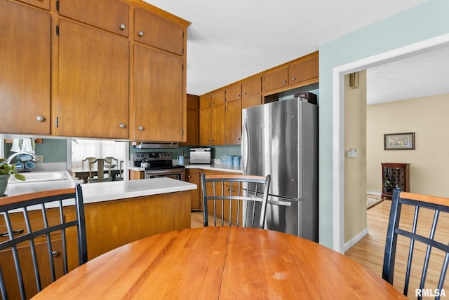 kitchen featuring appliances with stainless steel finishes, sink, and light hardwood / wood-style flooring