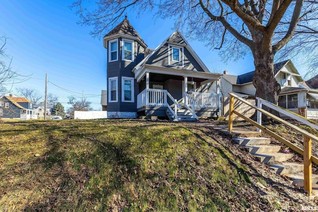 victorian house with stairs, a porch, and a front yard