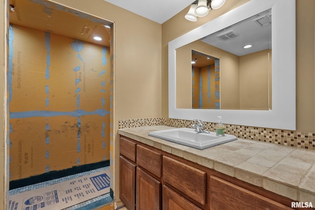 bathroom featuring vanity and decorative backsplash