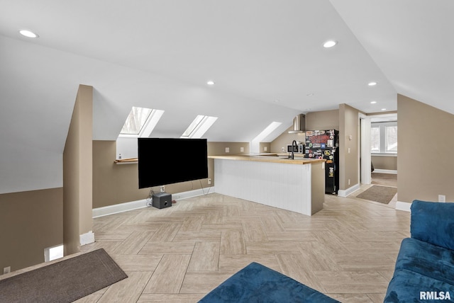 additional living space featuring light parquet flooring and lofted ceiling with skylight