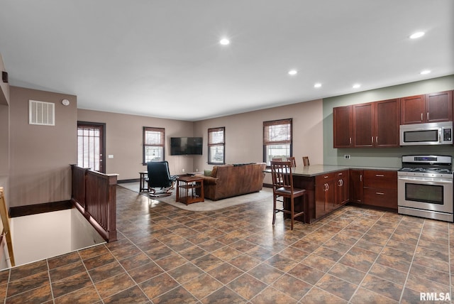 kitchen featuring a breakfast bar, stainless steel appliances, and kitchen peninsula