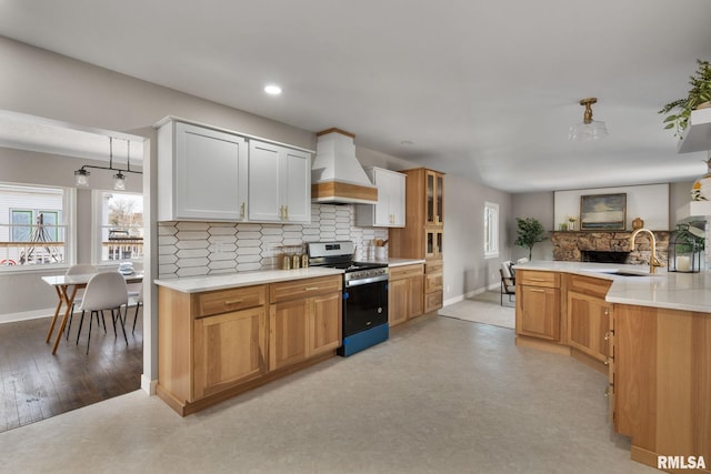 kitchen with tasteful backsplash, sink, stainless steel range, and premium range hood