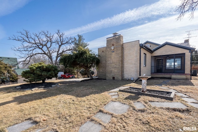 view of side of property with a yard and central AC