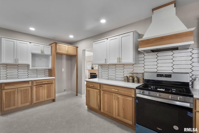 kitchen with white cabinets, custom range hood, stainless steel gas range, and decorative backsplash