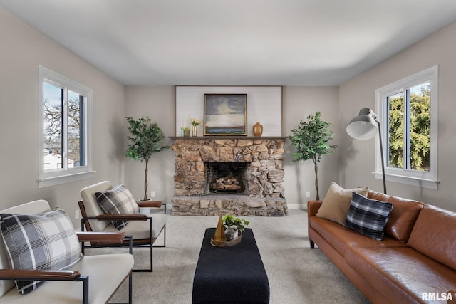 living room featuring a stone fireplace and carpet floors