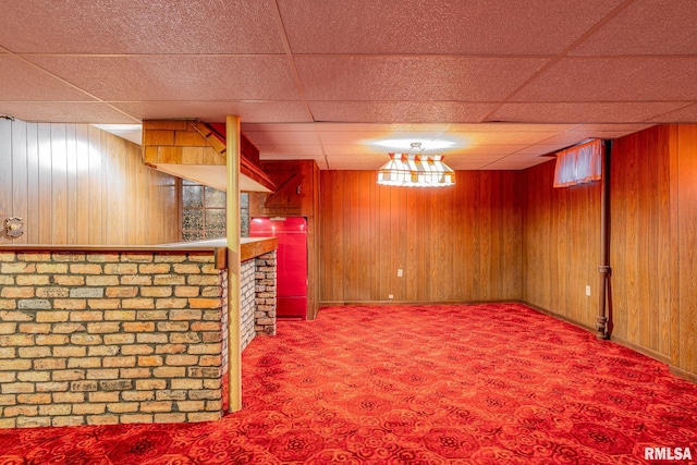 bar with carpet, a drop ceiling, and wood walls