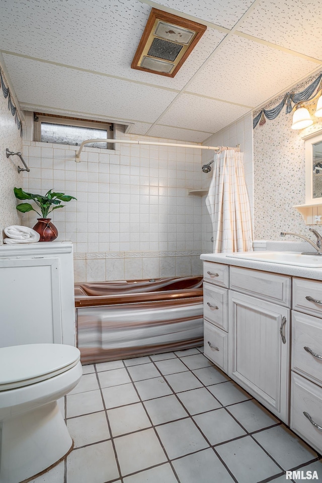 full bathroom with shower / tub combo, vanity, toilet, and a drop ceiling