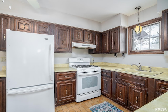 kitchen with white appliances, sink, light tile patterned flooring, hanging light fixtures, and dark brown cabinets