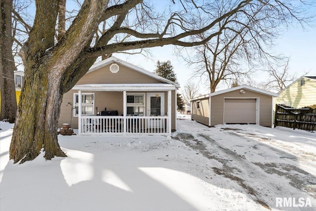 view of front facade with a garage, an outbuilding, and a porch