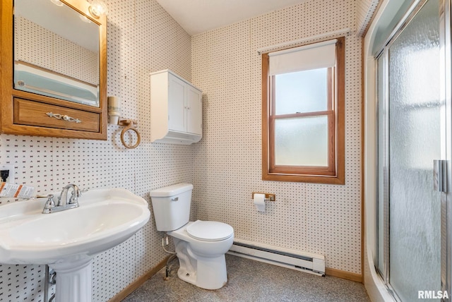 bathroom featuring toilet, sink, a shower with door, and a baseboard radiator