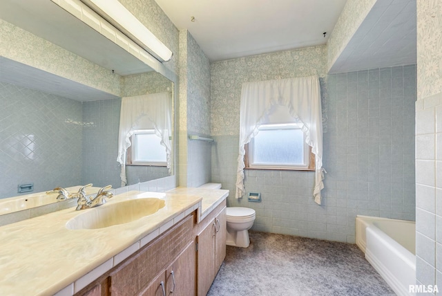 bathroom featuring toilet, tile walls, plenty of natural light, and vanity