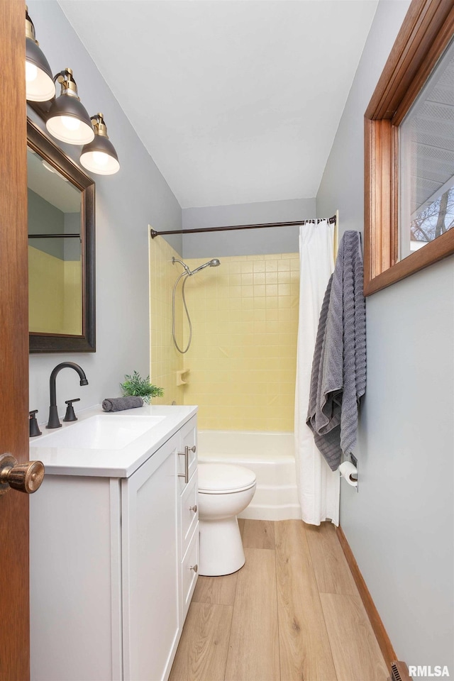 full bathroom featuring shower / tub combo with curtain, toilet, hardwood / wood-style flooring, and vanity