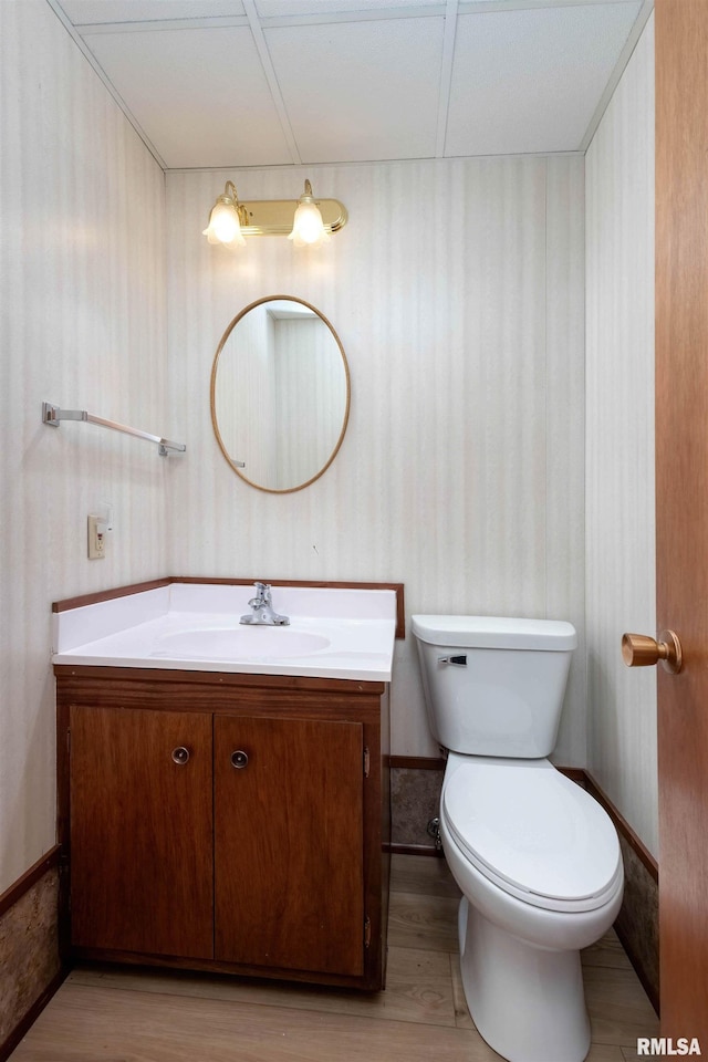 bathroom featuring wood-type flooring, vanity, and toilet