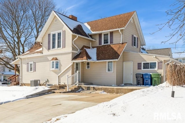 snow covered rear of property with central AC