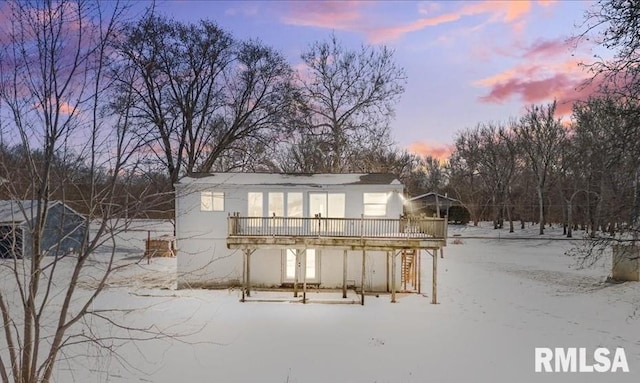 snow covered rear of property featuring a deck