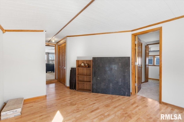 unfurnished living room featuring track lighting, light wood-type flooring, and crown molding