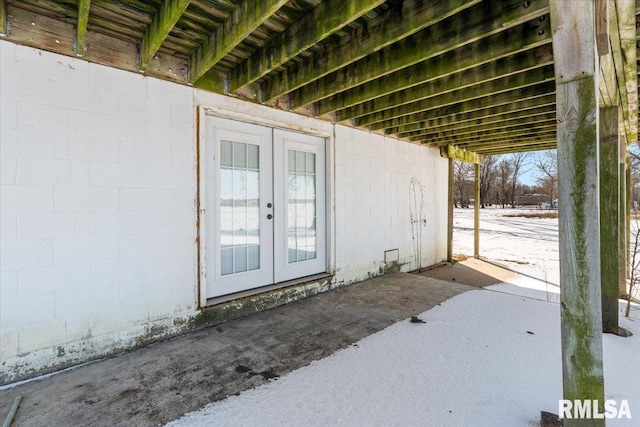 snow covered patio featuring french doors