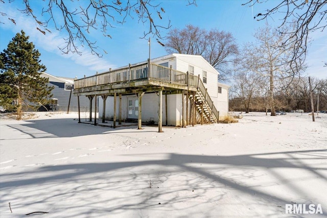 snow covered house with a wooden deck