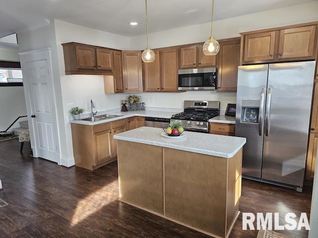 kitchen with sink, a center island, pendant lighting, stainless steel appliances, and dark hardwood / wood-style flooring