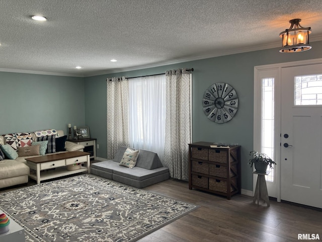 living room featuring a textured ceiling, dark wood-type flooring, and ornamental molding