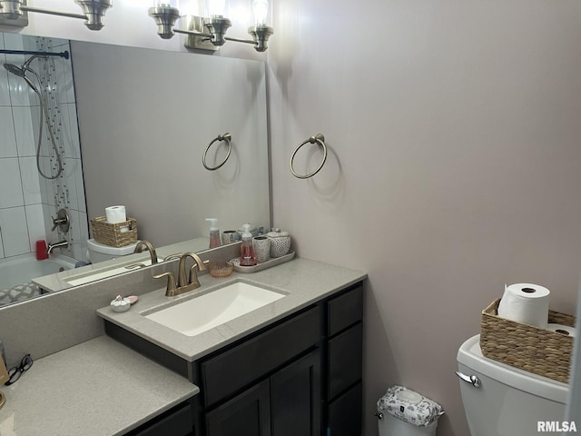 full bathroom featuring tiled shower / bath combo, vanity, and toilet