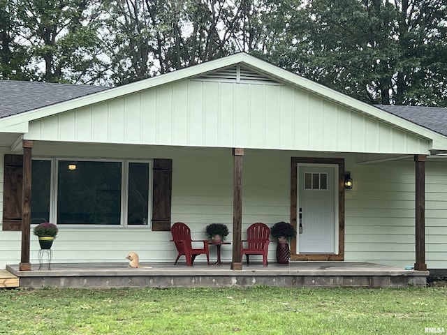 view of front of property with a front yard, a porch, and roof with shingles