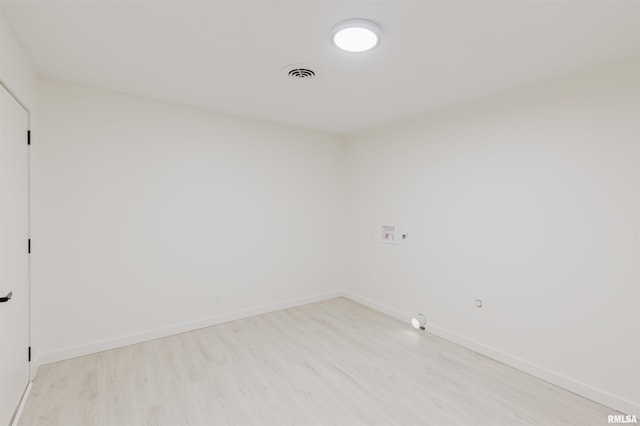 spare room featuring light wood finished floors, baseboards, and visible vents