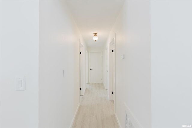 hall with light wood-type flooring and baseboards